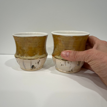 Load image into Gallery viewer, Hand holding one ceramic bourbon tumbler in the ceramic bourbon tumbler set.