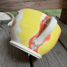 Load image into Gallery viewer, Decorative ceramic bowl with yellow and orange design on a wooden surface