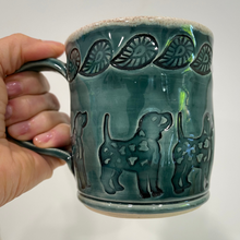 Load image into Gallery viewer, Hand holding green dog pottery mug.