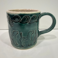 Load image into Gallery viewer, Green pottery mug with dog and leaf designs imprinted in the clay.