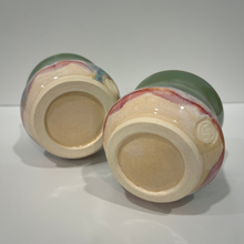 Load image into Gallery viewer, Two pottery drink tumblers laying on their sides with bottoms showing.