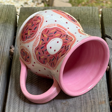 Load image into Gallery viewer, Pink sprinkle donut mug laying on it's side with pink interior visible.