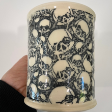 Load image into Gallery viewer, Ceramic mug with skull pattern held by a hand against a white background
