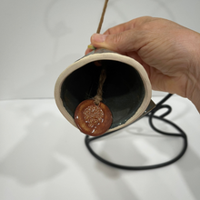 Load image into Gallery viewer, Ceramic bell with a decorative element held by a hand on a white background
