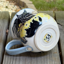 Load image into Gallery viewer, Bottom view of the black horse pottery mug showing off the double horseshoes.
