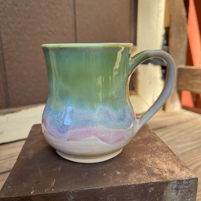Multicolored ceramic mug on a metal surface