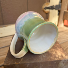 Load image into Gallery viewer, Colorful ceramic mug on a metal and wooden surface with a blurred background
