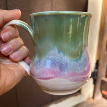 Load image into Gallery viewer, Hand holding a ceramic mug with a gradient design against a neutral background
