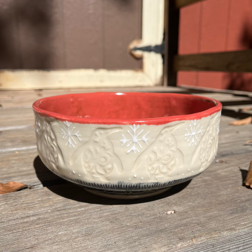 Ceramic bowl with red interior on a wooden surface