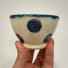 Load image into Gallery viewer, Hand holding a small ceramic blue polka dot pottery bowl.
