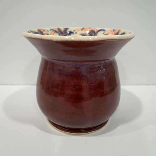 Small purple vase with floral rim.