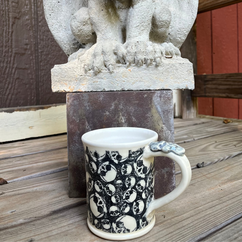 Skull Pottery Mug with gargoyle in background.