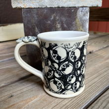 Load image into Gallery viewer, Ceramic mug with black skull pattern.

