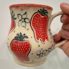 Load image into Gallery viewer, Ceramic mug with strawberry design held by a hand on a white background
