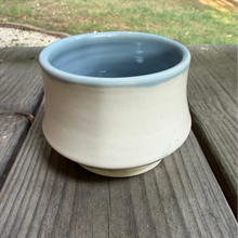 Load image into Gallery viewer, Ceramic cup with blue interior on a wooden surface
